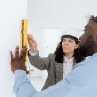 two contractors using a level tool on a wall indoors 110x110 - Miami Construction Excellence: Professional Standards