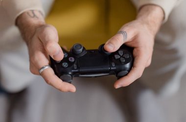 a persons hand holding a game controller 380x250 - Is FC 26 Career Mode Finally Realistic Enough? Discover