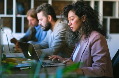 Focused colleagues working on laptops in office 380x250 - How to Scale Brand Strategy Efficiently Through AI
