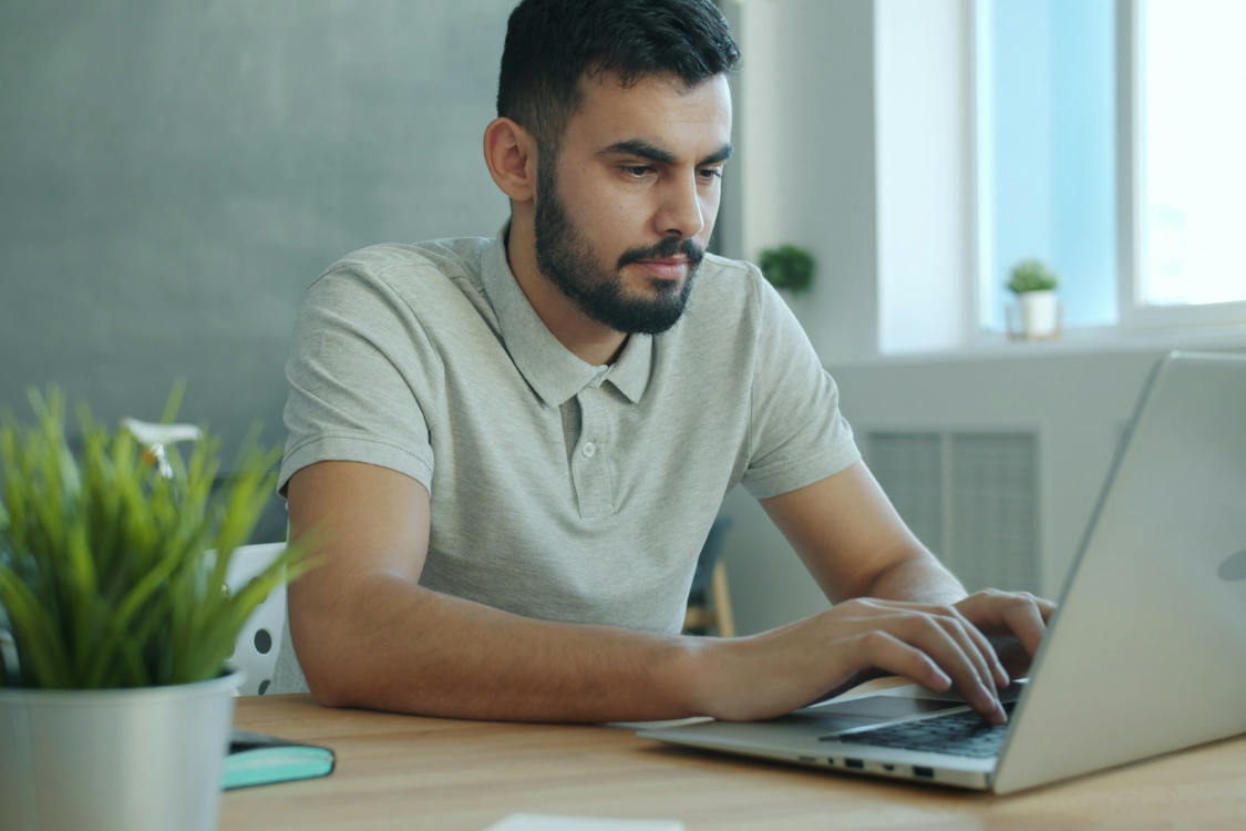 a man with beard typing on his laptop - 5 Key Differences Between RIS and PACS You Should Know