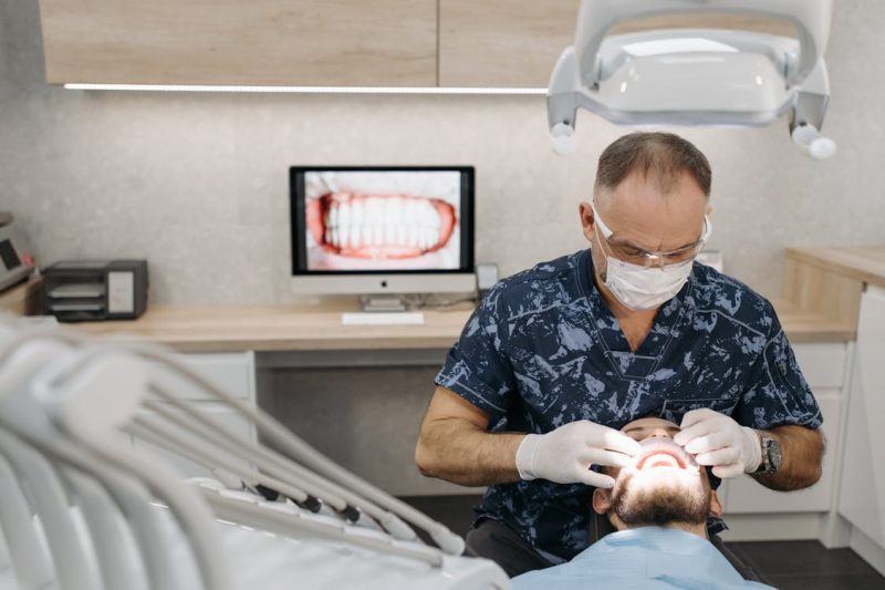 Dentist in surgical mask performing a dental check up on a patient 800x533 - The IRS Just Raised HSA Limits for 2026 — Here's Why That Matters for Texas Patients Considering Full-Mouth Implants