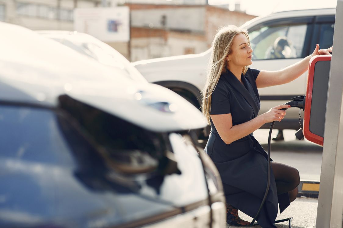 Used Electric Cars Jumped 32% in Three Months, and Families Are Driving Most of It a woman charging her electric car - Used Electric Cars Jumped 32% in Three Months, and Families Are Driving Most of It