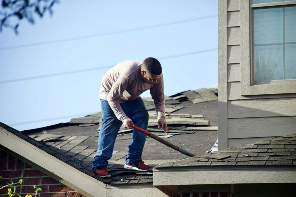 Why Hail Season Puts Austin Roofing Reviews Under a Microscope Roofer tearing the roof apart 1024x683 - Why Hail Season Puts Austin Roofing Reviews Under a Microscope